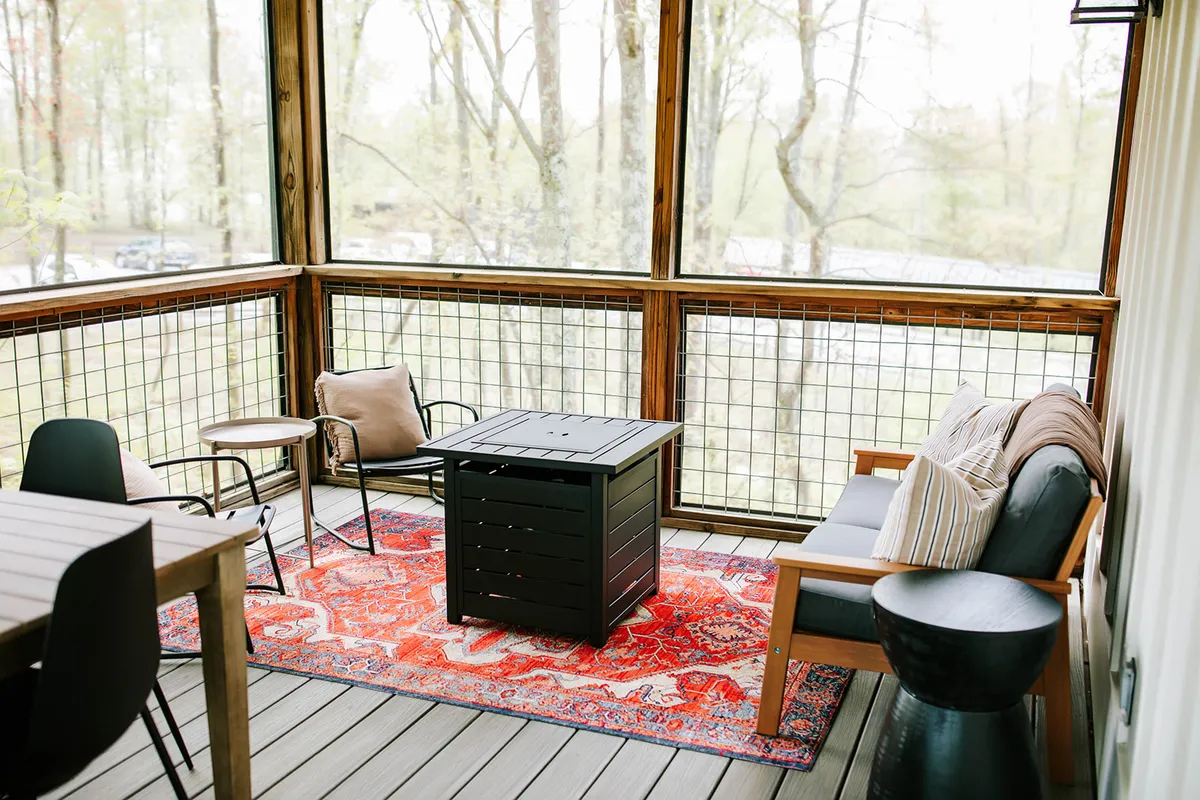 A bright, comfortable living area featuring a rug, coffee table, couch, and chairs—an ideal space for relaxing, socializing, or hosting small gatherings before or after wedding events.